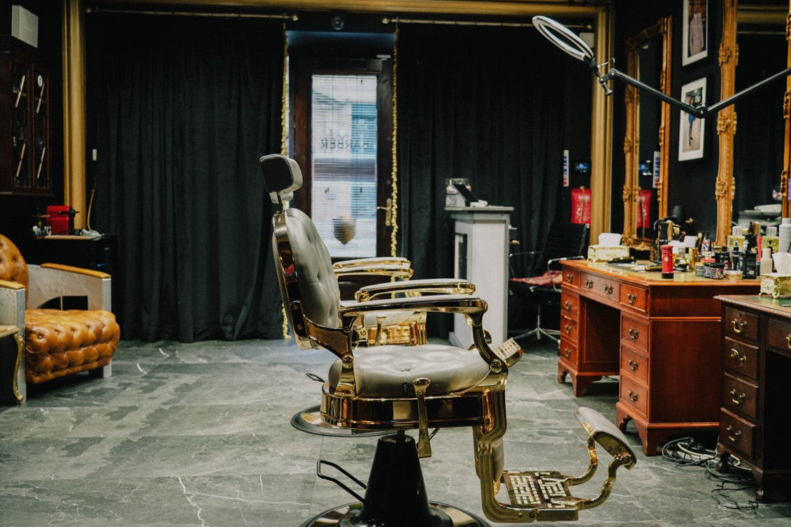 Private barbering studio with a traditional chair, dark curtains and polished wood cabinetry