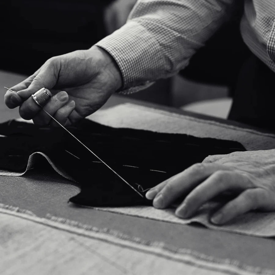 A tailor cutting cloth by hand for a business tailoring commission